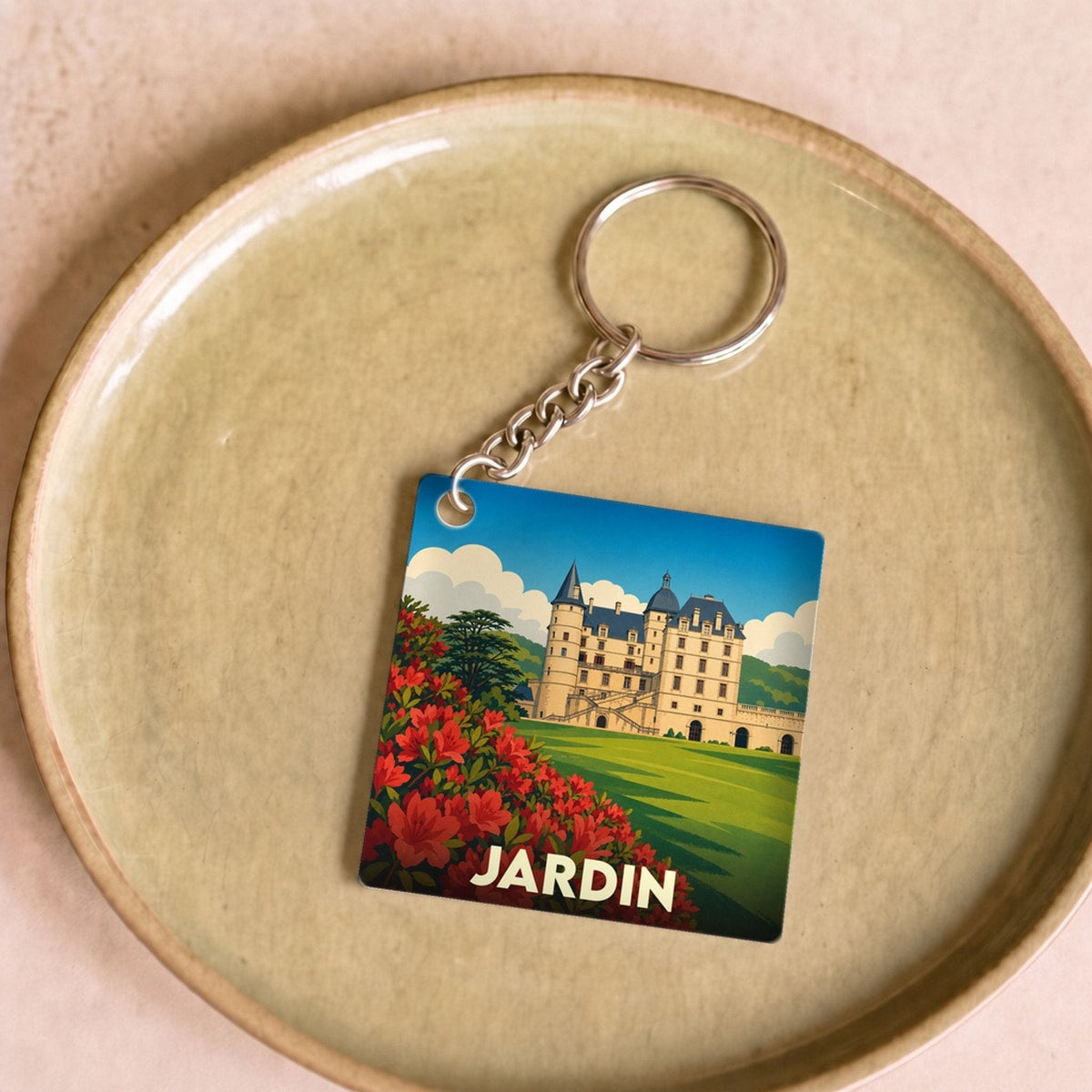 Porte-clés souvenir de la ville de Jardin avec une illustration stylisée d'un château et de fleurs rouges.