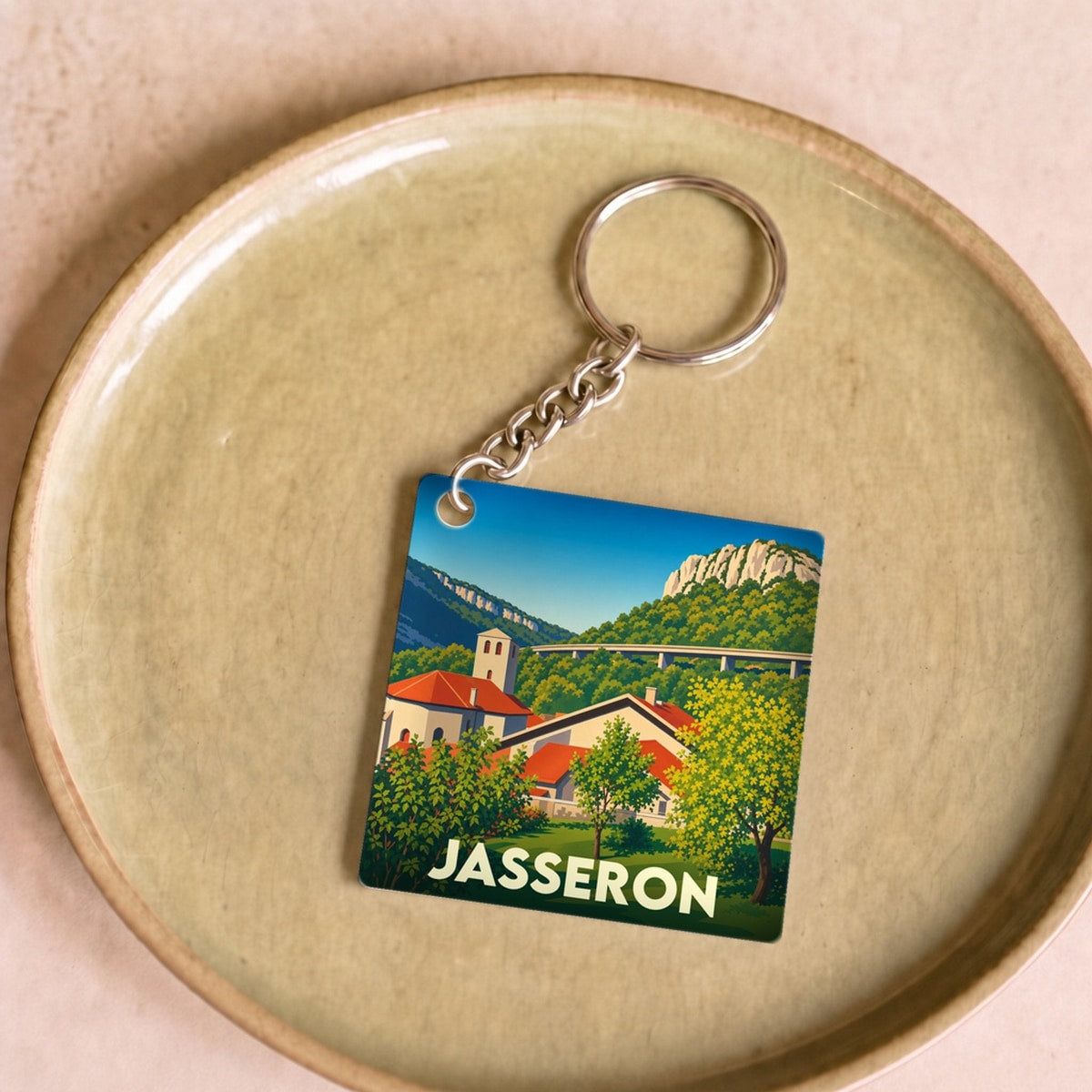 Porte-clés souvenir de la ville de Jasseron avec une illustration stylisée.