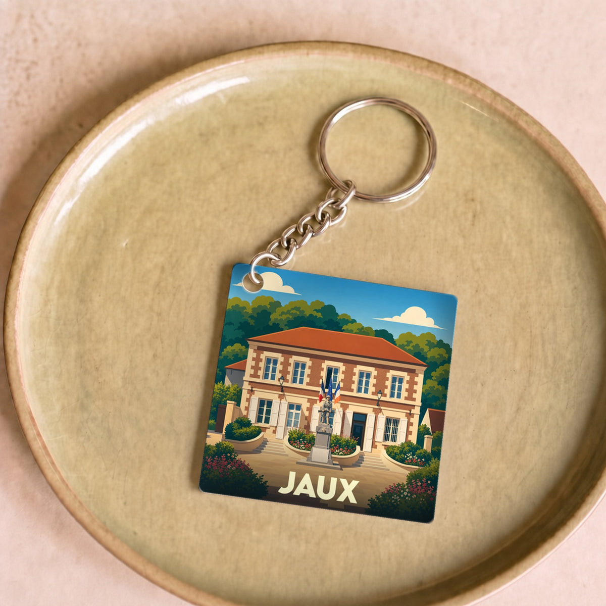 Porte-clés souvenir de la ville de Jaux avec une illustration stylisée de sa mairie.
