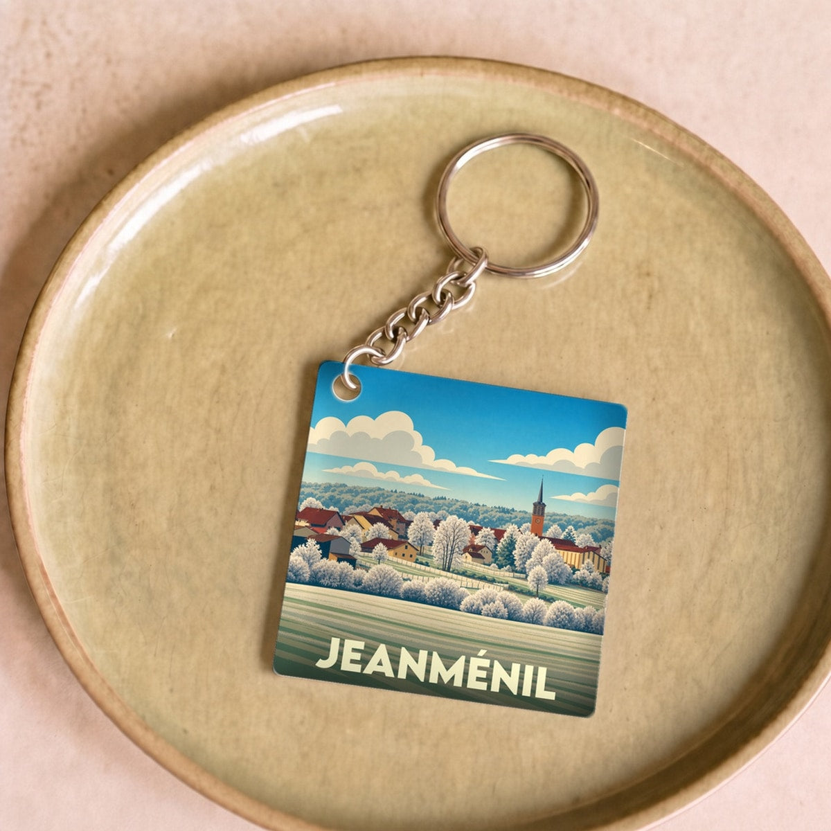 Porte-clés souvenir de la ville de Jeanménil avec une illustration stylisée.