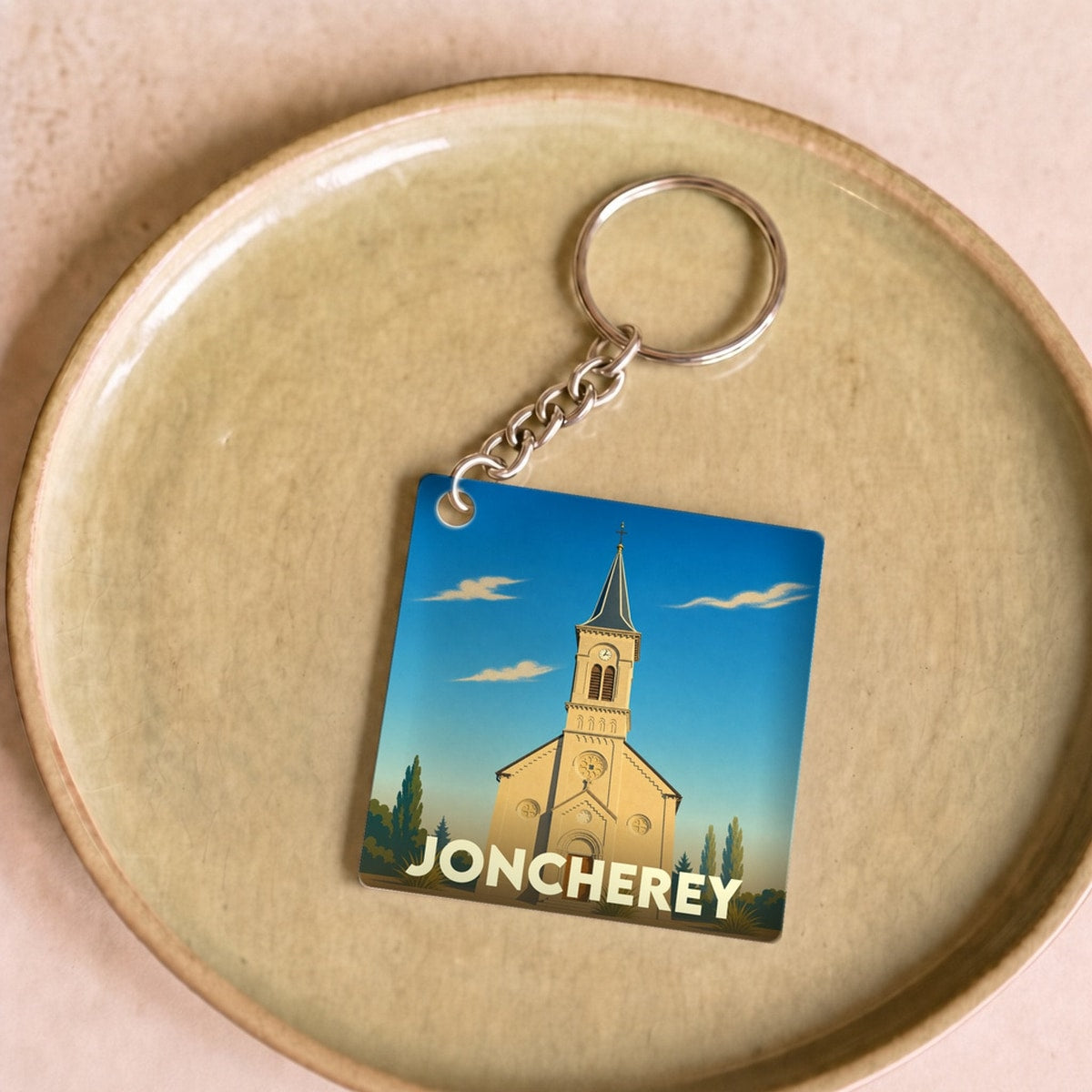 Porte-clés souvenir de la ville de Joncherey avec une illustration stylisée de son église.