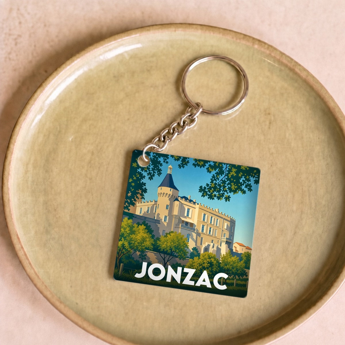 Porte-clés souvenir de la ville de Jonzac avec une illustration stylisée de son château.