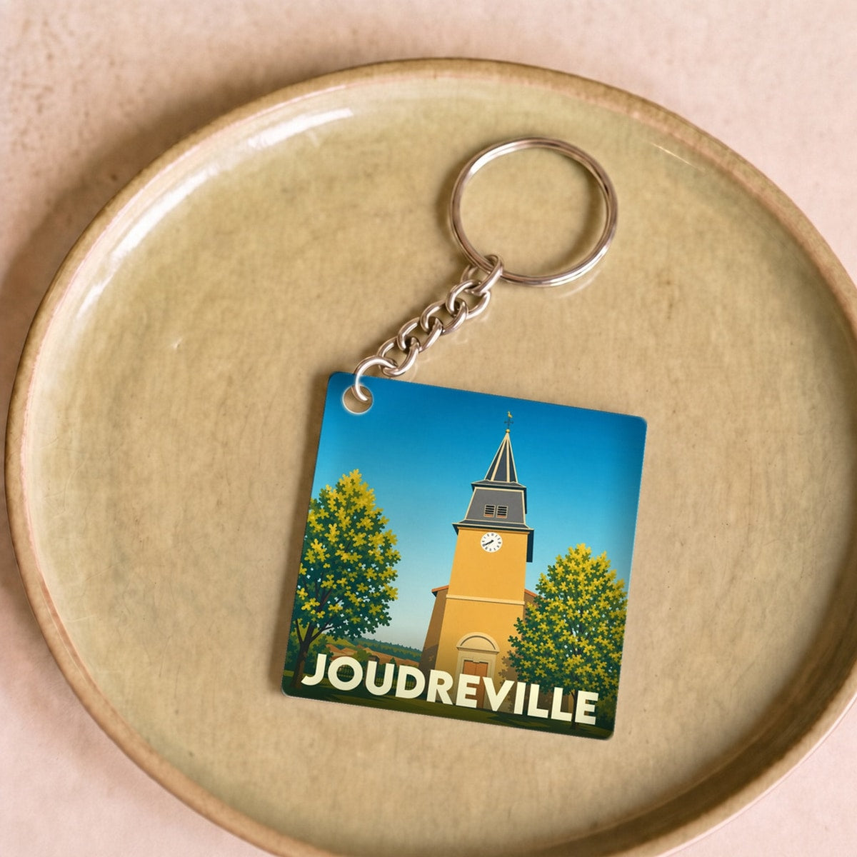Porte-clés souvenir de la ville de Joudreville avec une illustration stylisée de son église.