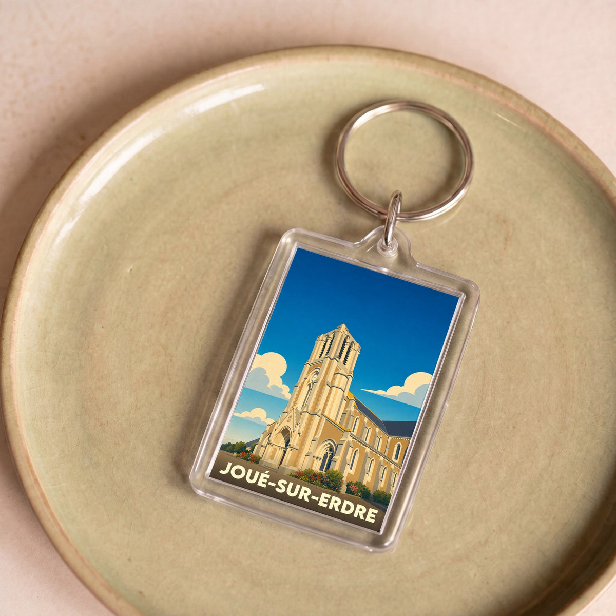 Porte-clés souvenir de la ville de Joué-sur-Erdre avec une illustration stylisée de son église.