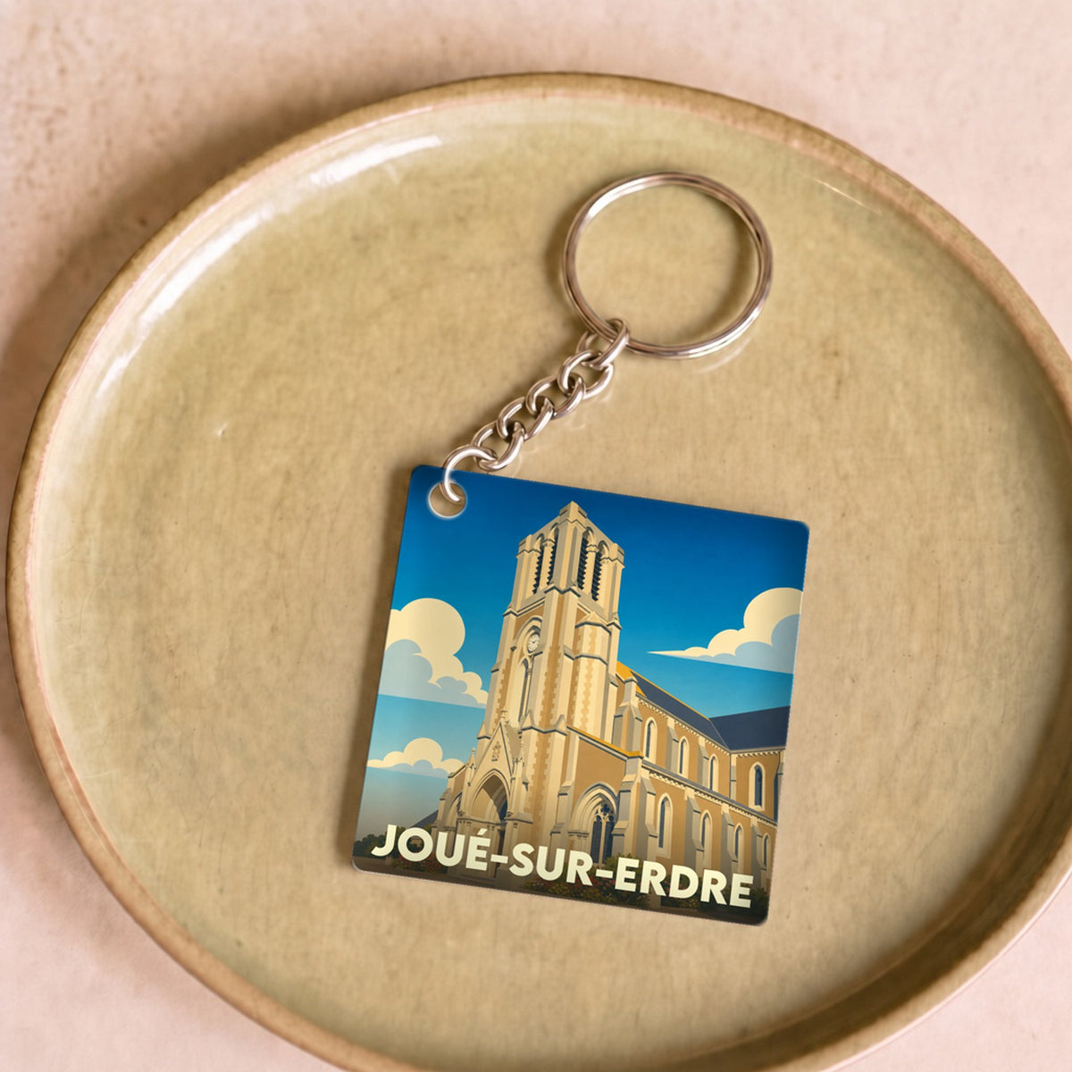 Porte-clés souvenir de la ville de Joué-sur-Erdre avec une illustration stylisée de son église.