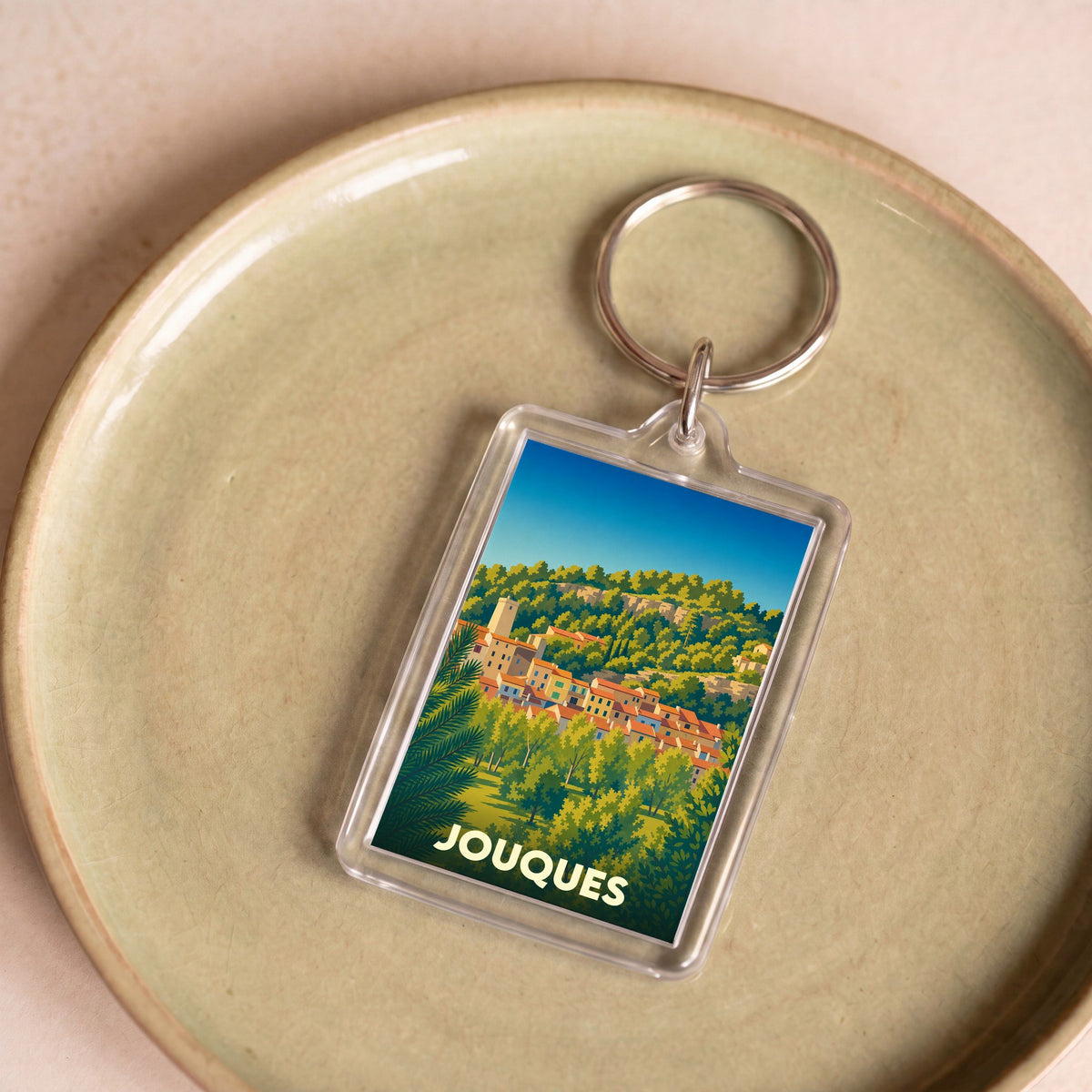 Porte-clés souvenir de la ville de Jouques avec une illustration stylisée.