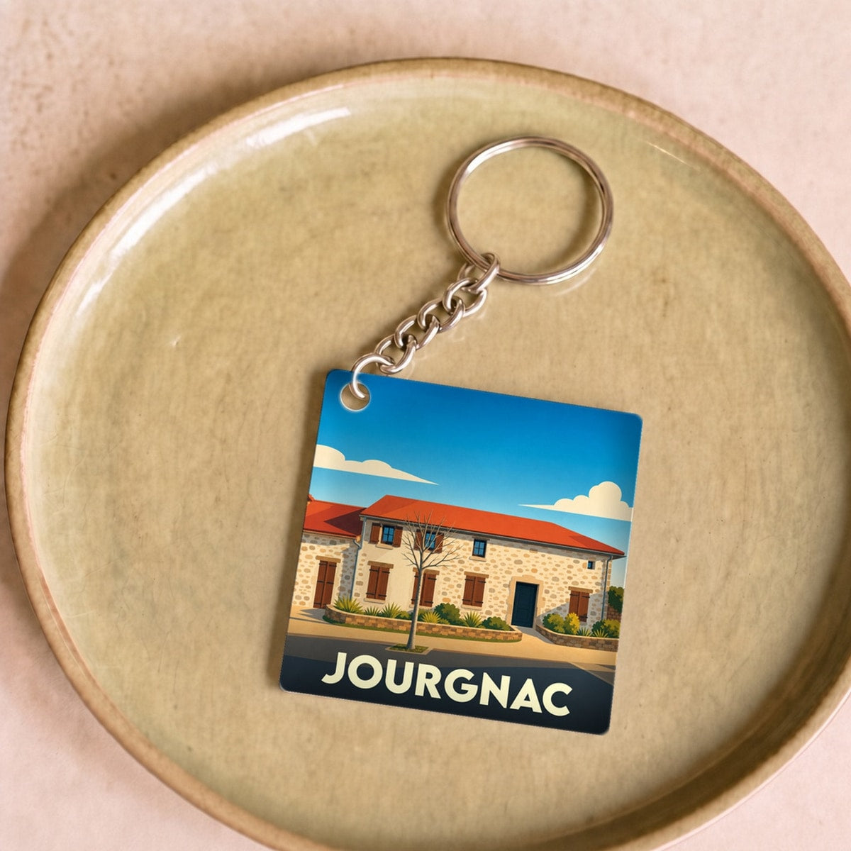 Porte-clés souvenir de la ville de Jourgnac avec une illustration stylisée.