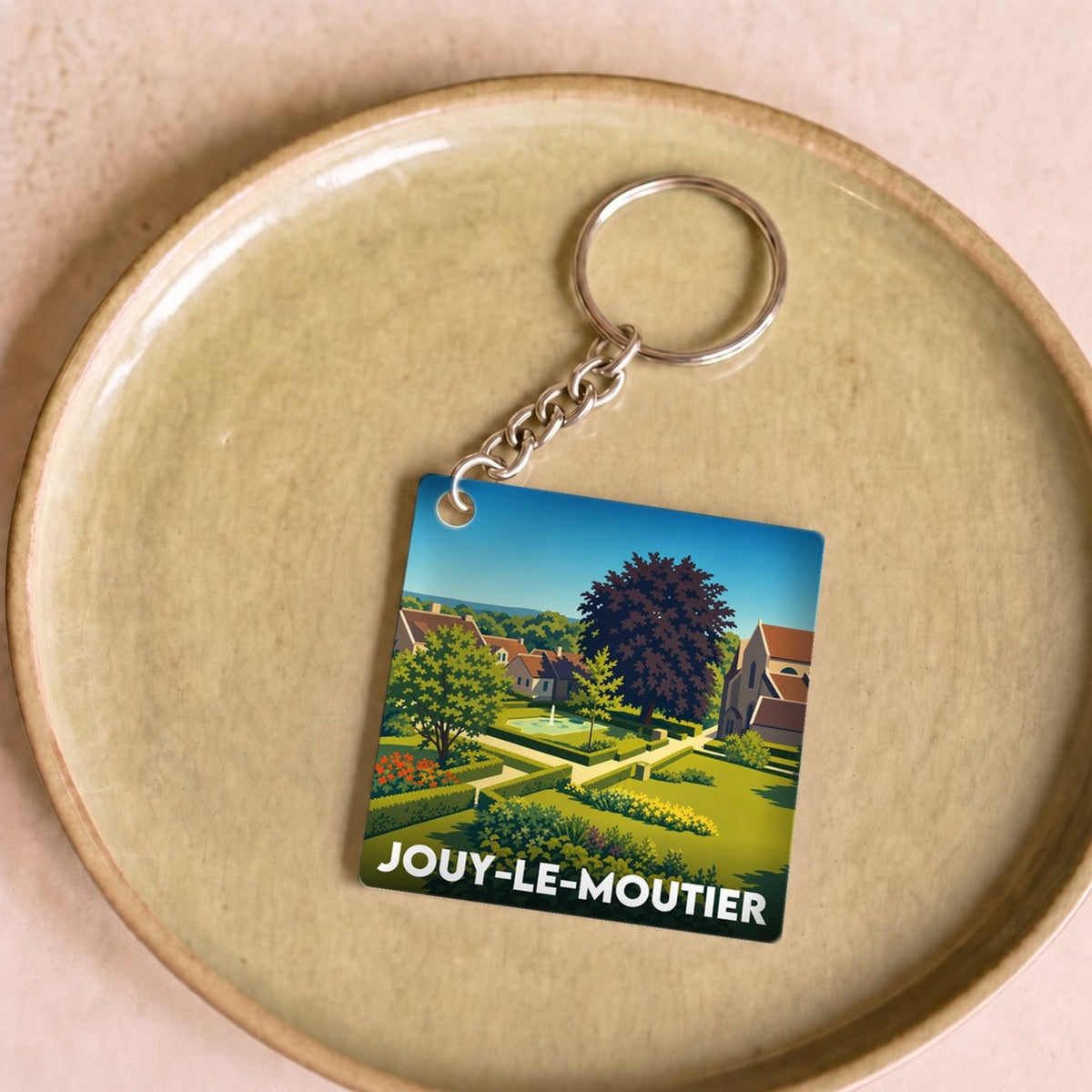 Porte-clés souvenir de la ville de Jouy-le-Moutier avec une illustration stylisée.