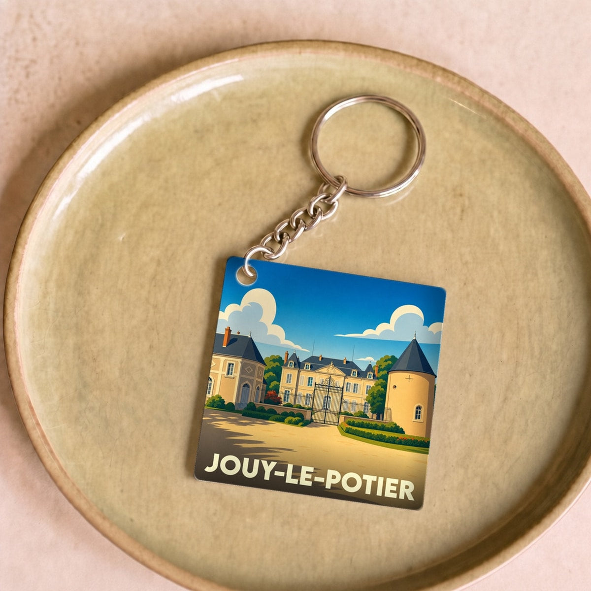 Porte-clés souvenir de la ville de Jouy-le-Potier avec une illustration stylisée de son patrimoine.