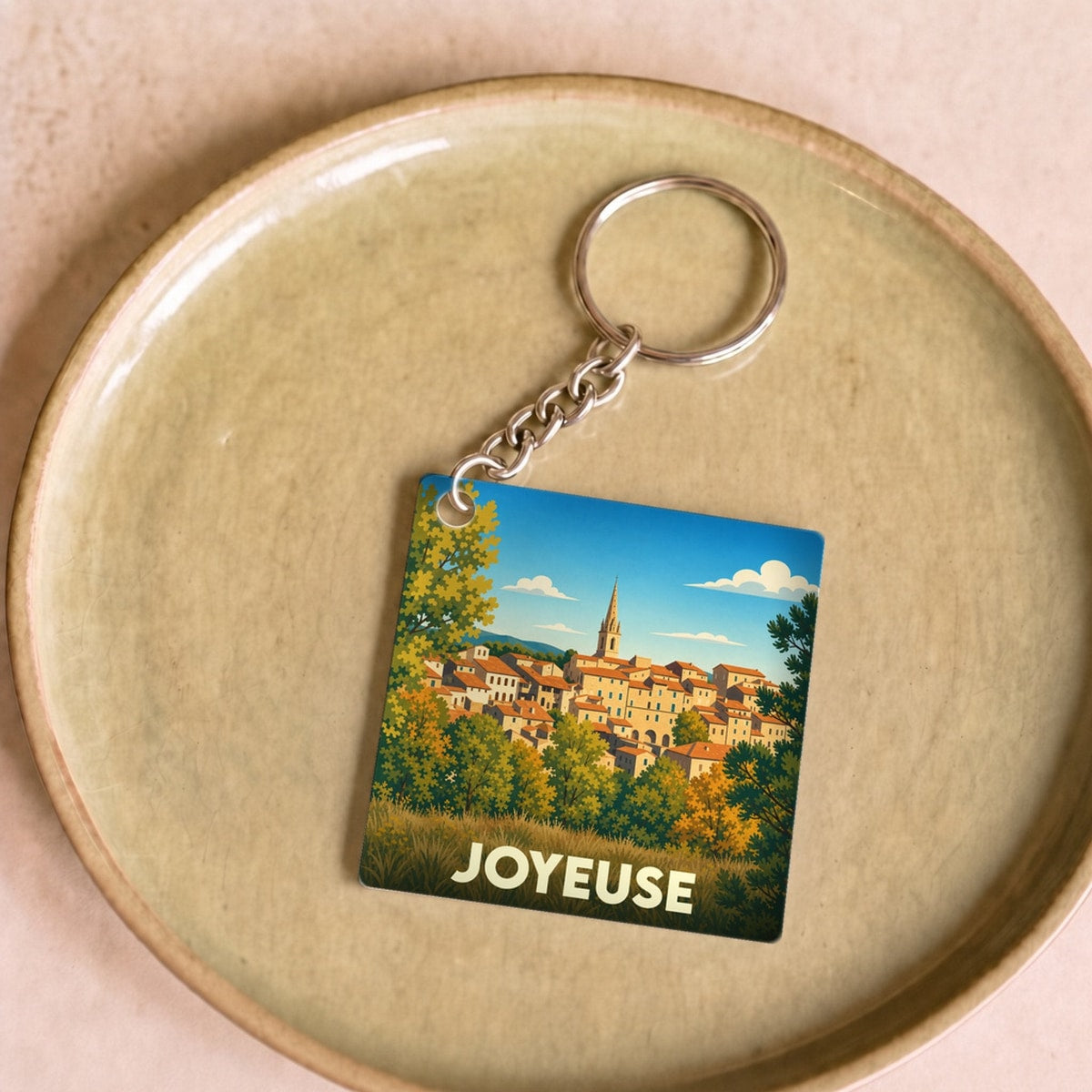 Porte-clés souvenir de la ville de Joyeuse avec une illustration stylisée.