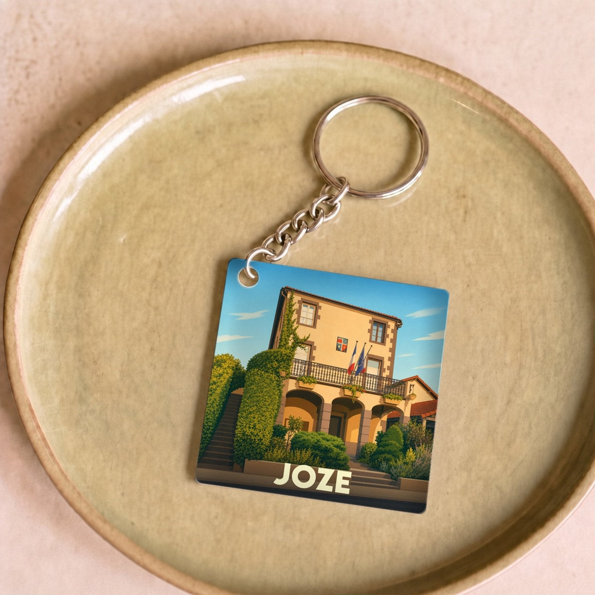 Porte-clés souvenir de la ville de Joze avec une illustration stylisée de sa mairie.