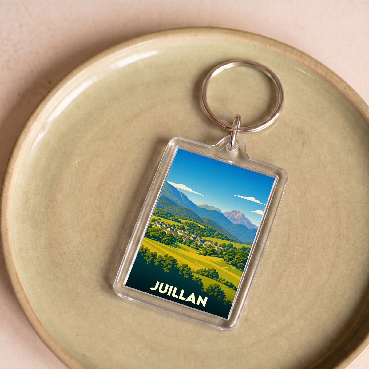 Porte-clés souvenir de la ville de Juillan avec une illustration paysagère stylisée.