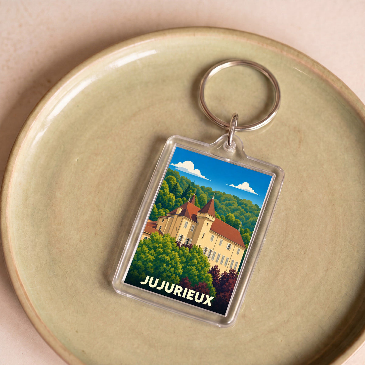 Porte-clés souvenir de la ville de Jujurieux avec une illustration stylisée de son château.