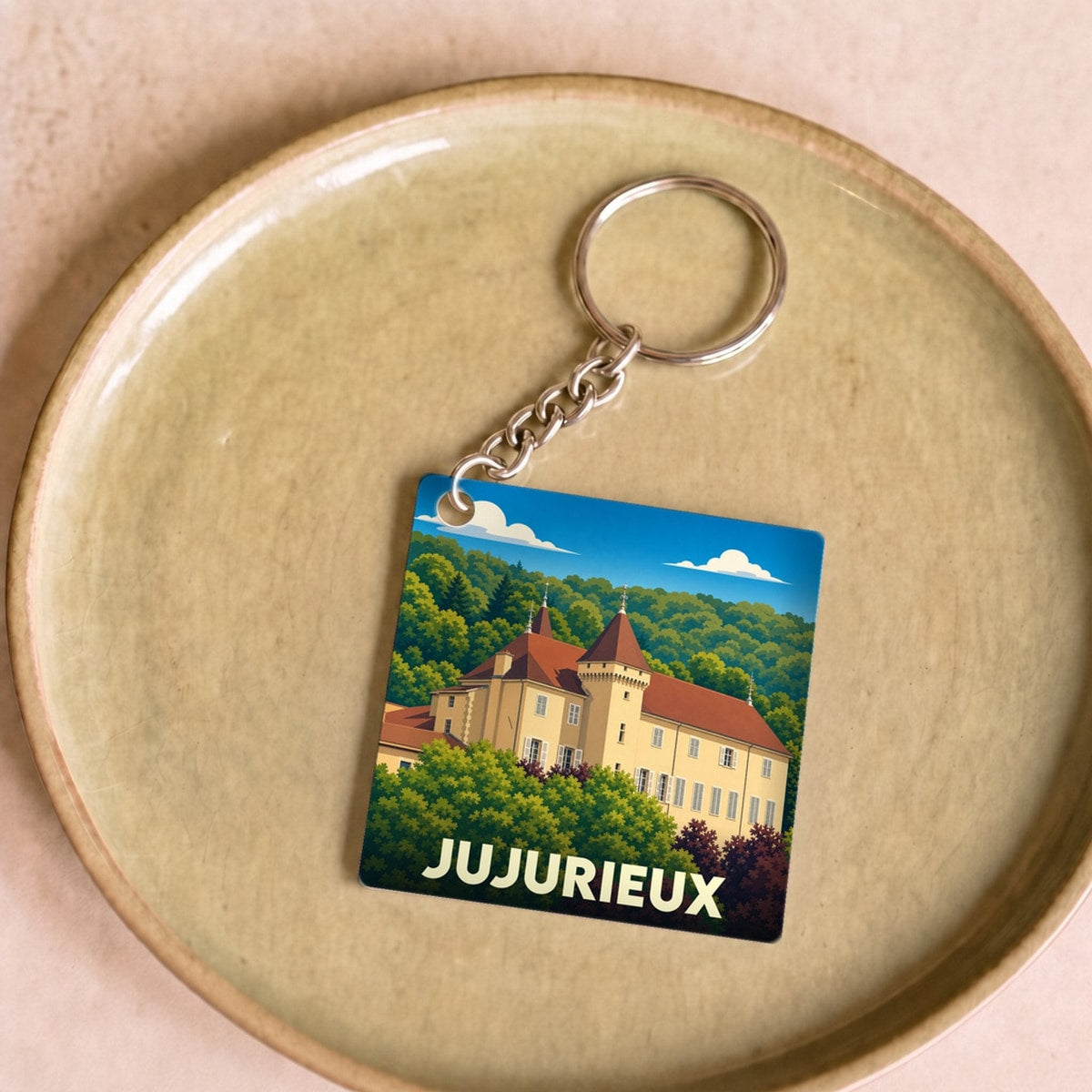 Porte-clés souvenir de la ville de Jujurieux avec une illustration stylisée de son château.