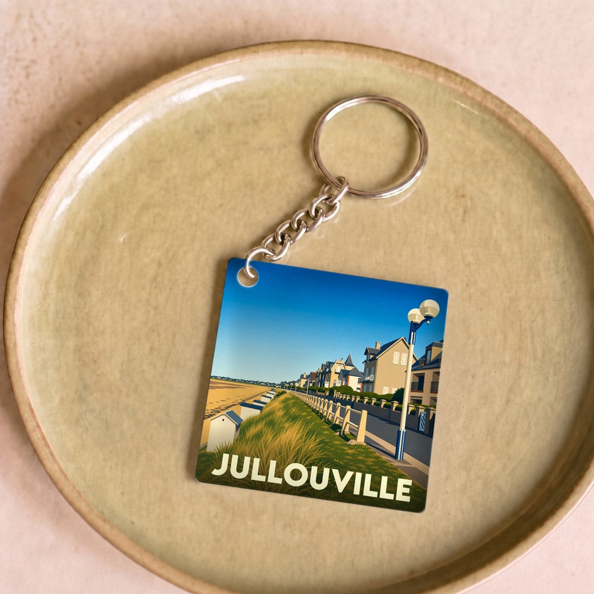 Porte-clés souvenir de la ville de Jullouville avec une illustration stylisée de son front de mer.