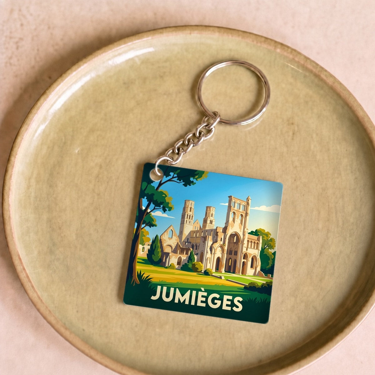 Porte-clés souvenir de la ville de Jumièges avec une illustration stylisée de son abbaye.