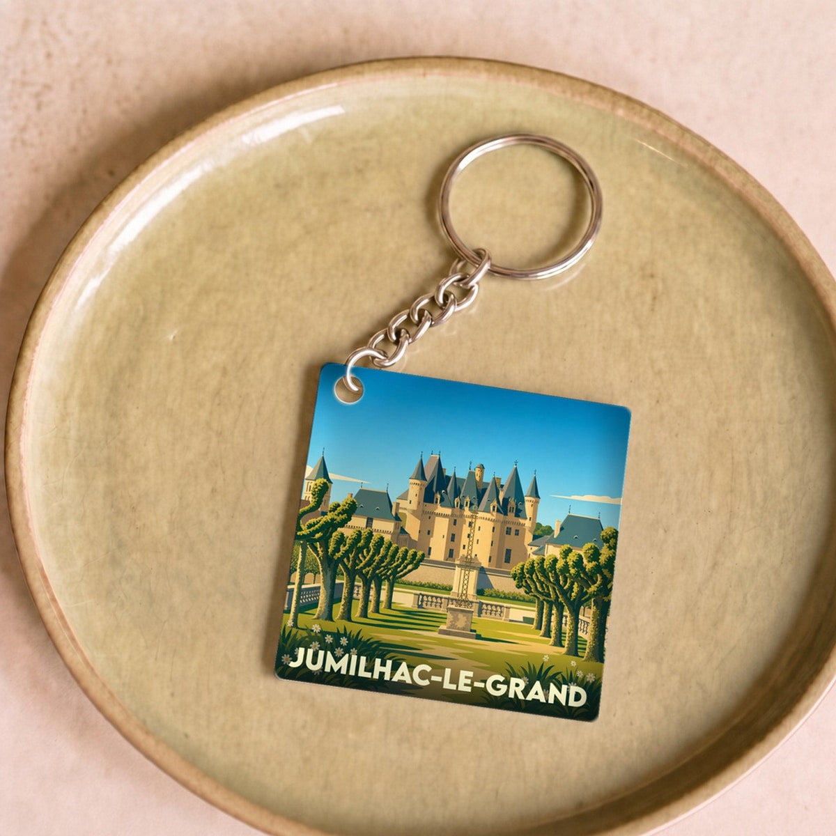 Porte-clés souvenir de la ville de Jumilhac-le-Grand avec une illustration stylisée de son château.