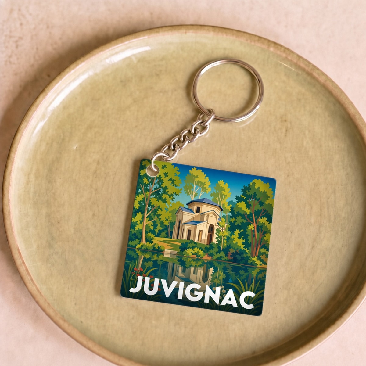 Porte-clés souvenir de la ville de Juvignac avec une illustration stylisée.