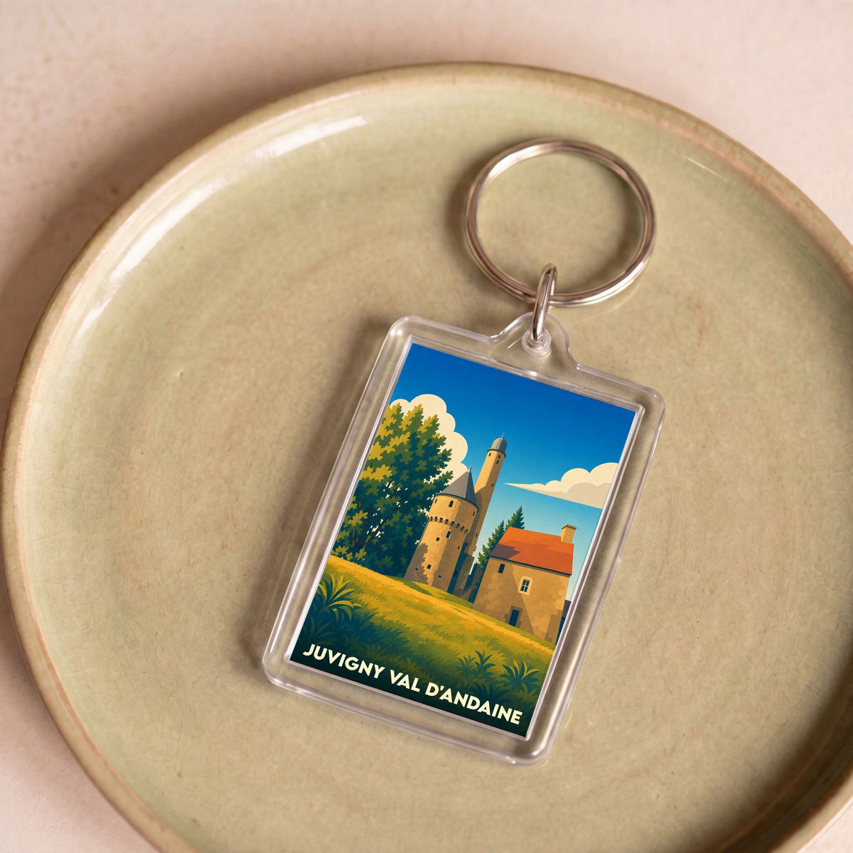 Porte-clés souvenir de la ville de Juvigny Val d'Andaine avec une illustration stylisée.