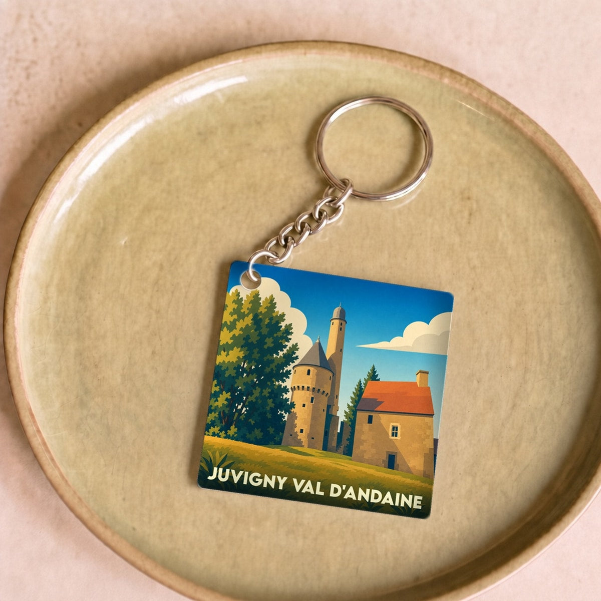 Porte-clés souvenir de la ville de Juvigny Val d'Andaine avec une illustration stylisée.