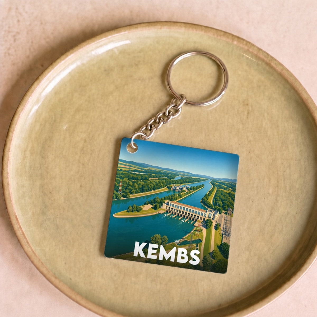 Porte-clés souvenir de la ville de Kembs avec une illustration stylisée de son barrage.