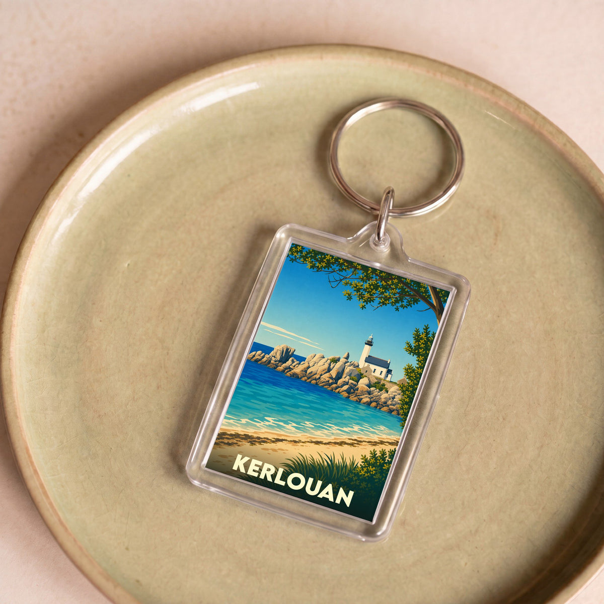 Porte-clés souvenir de la ville de Kerlouan avec une illustration stylisée de sa côte et de son phare.