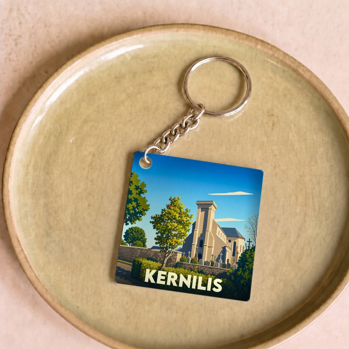 Porte-clés souvenir de la ville de Kernilis avec une illustration stylisée de son église.