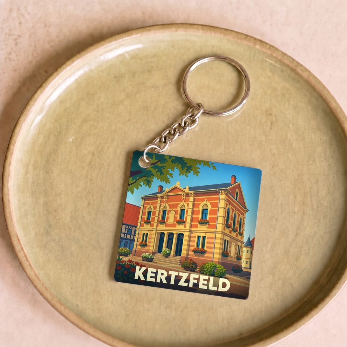 Porte-clés souvenir de la ville de Kertzfeld avec une illustration stylisée d'un bâtiment historique.