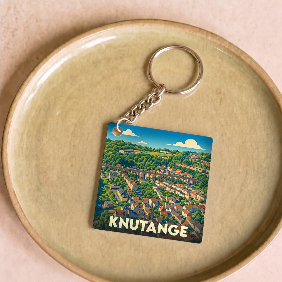 Porte-clés souvenir de la ville de Knutange avec une illustration stylisée.