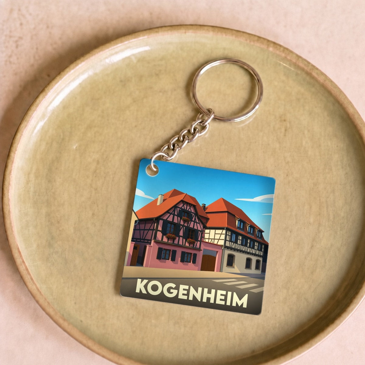 Porte-clés souvenir de la ville de Kogenheim avec une illustration stylisée de maisons à colombages.