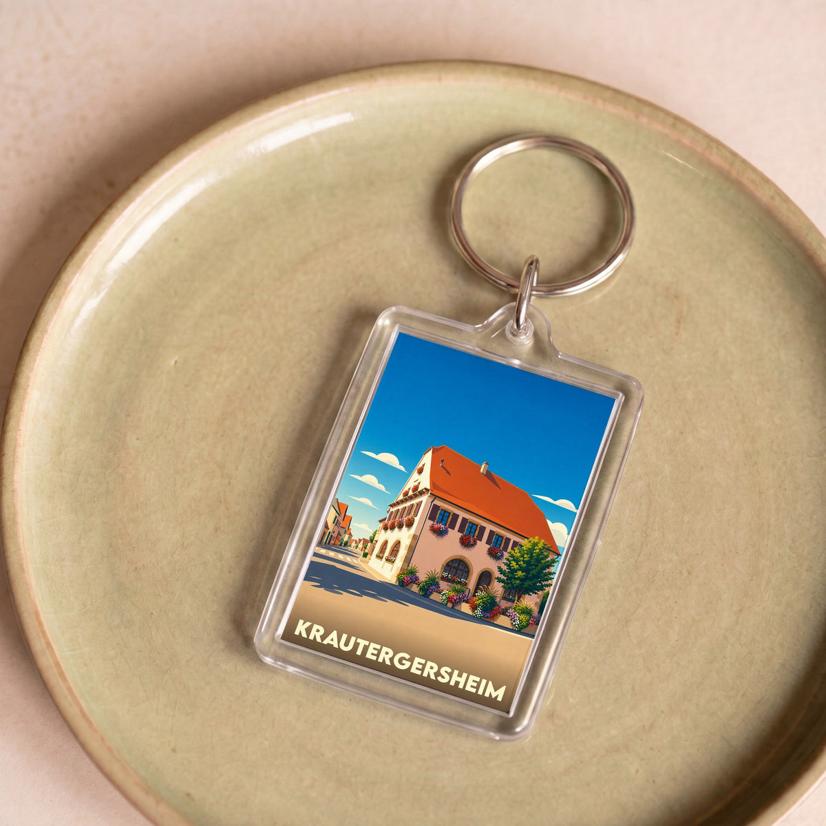 Porte-clés souvenir de la ville de Krautergersheim avec une illustration stylisée d'une maison alsacienne fleurie.