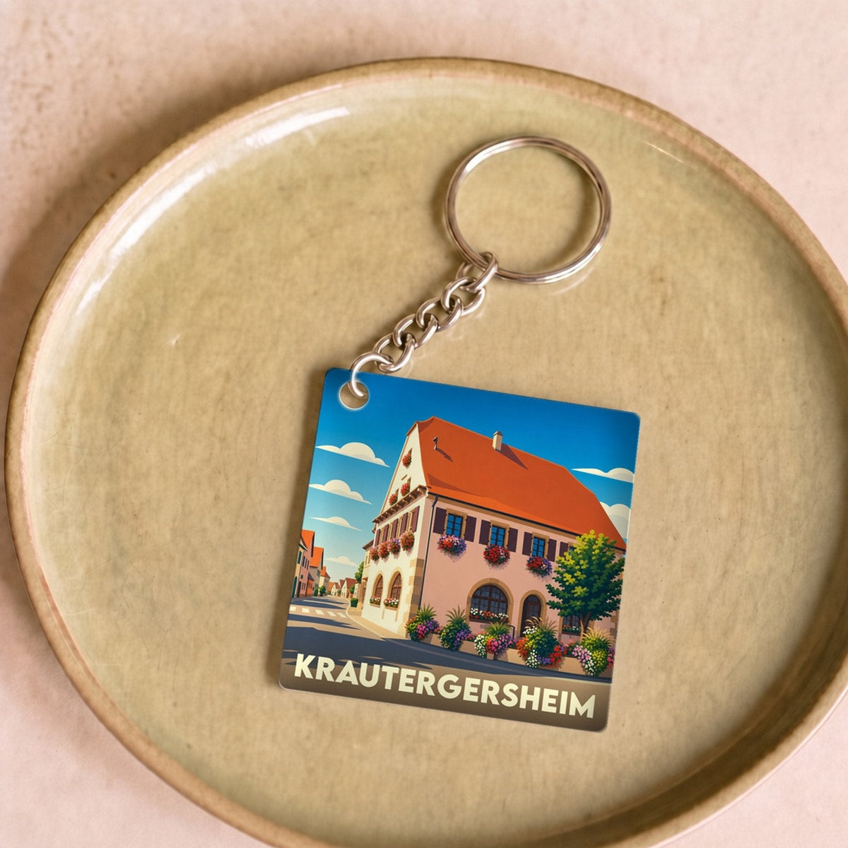 Porte-clés souvenir de la ville de Krautergersheim avec une illustration stylisée d'une maison alsacienne fleurie.