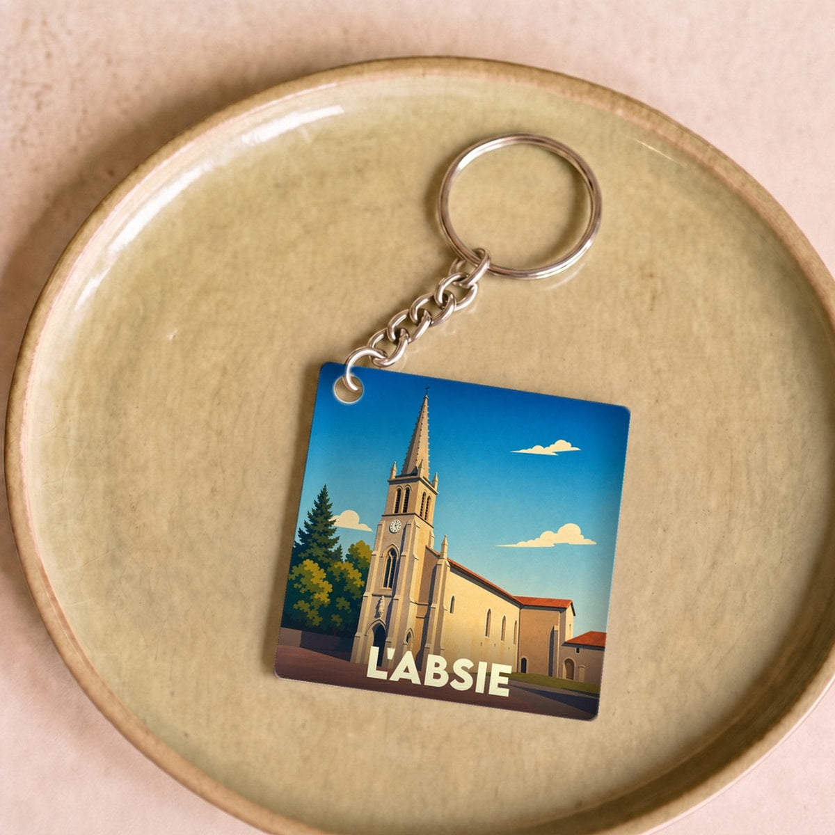 Porte-clés souvenir de la ville de L'Absie avec une illustration stylisée de son église.
