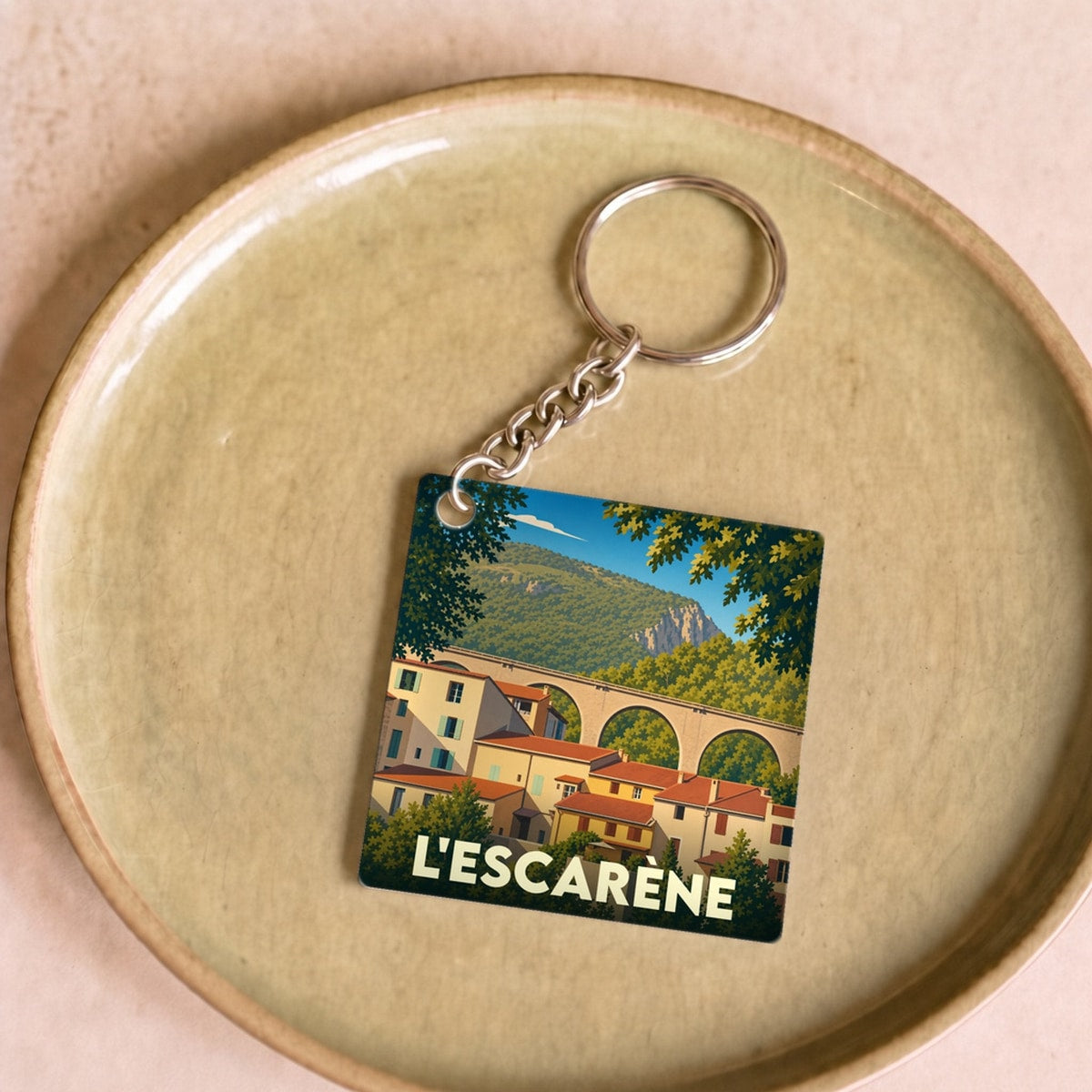 Porte-clés souvenir de la ville de L'Escarène avec une illustration stylisée.