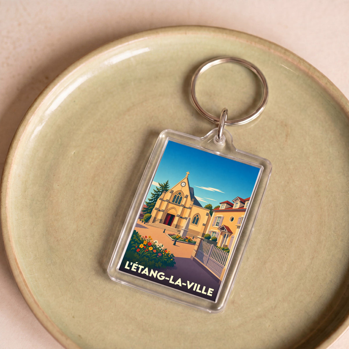 Porte-clés souvenir de la ville de L'Étang-la-Ville avec une illustration stylisée.