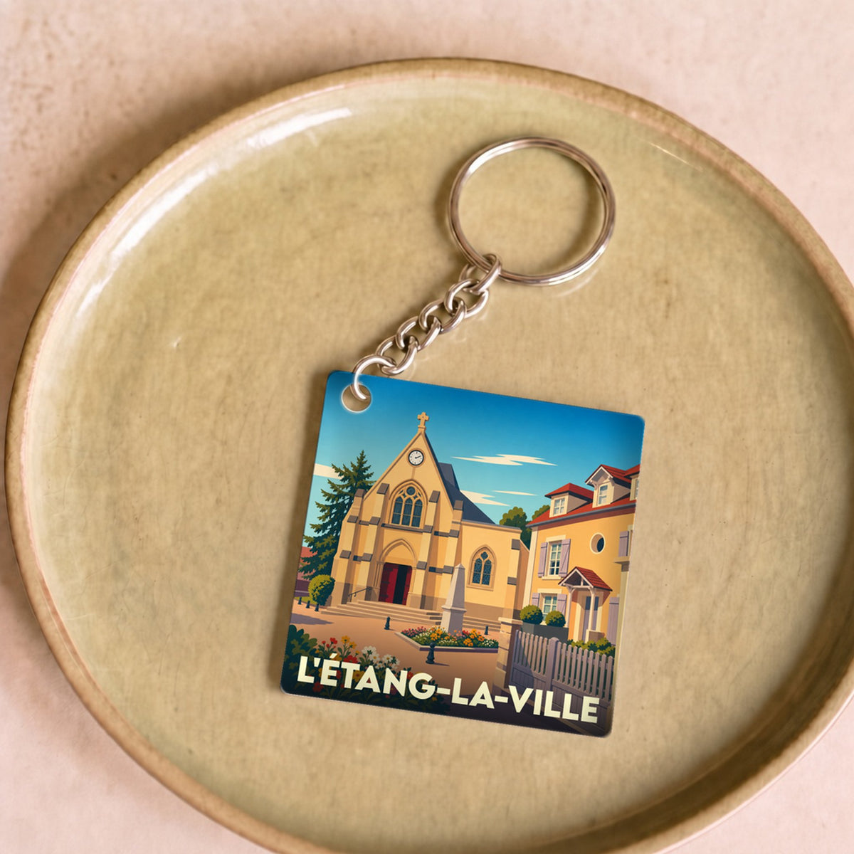 Porte-clés souvenir de la ville de L'Étang-la-Ville avec une illustration stylisée.
