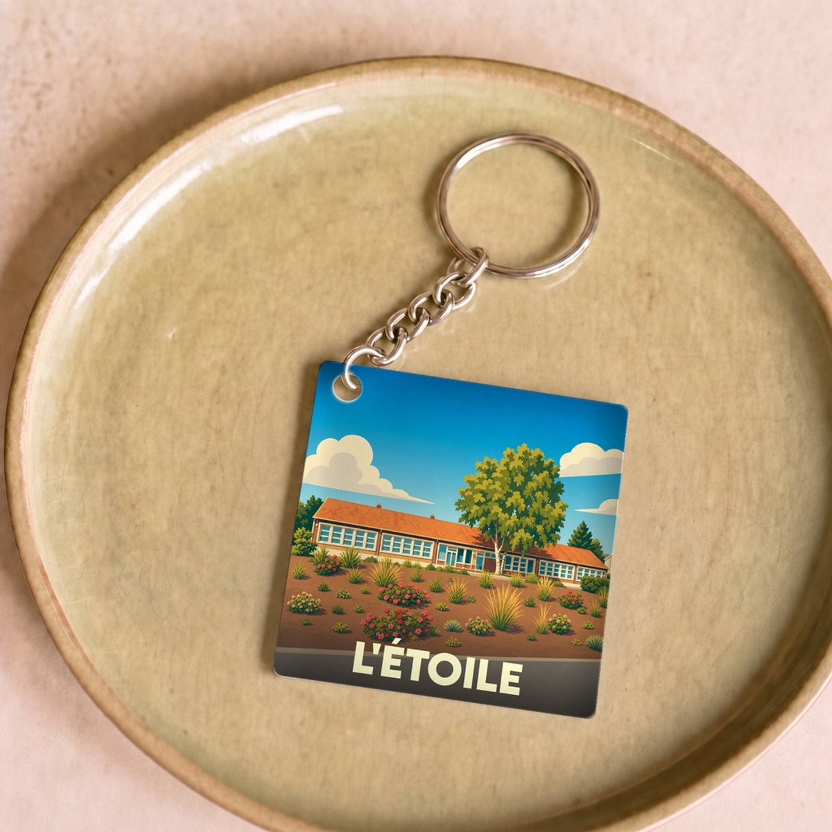 Porte-clés souvenir de la ville de L'Étoile avec une illustration stylisée.