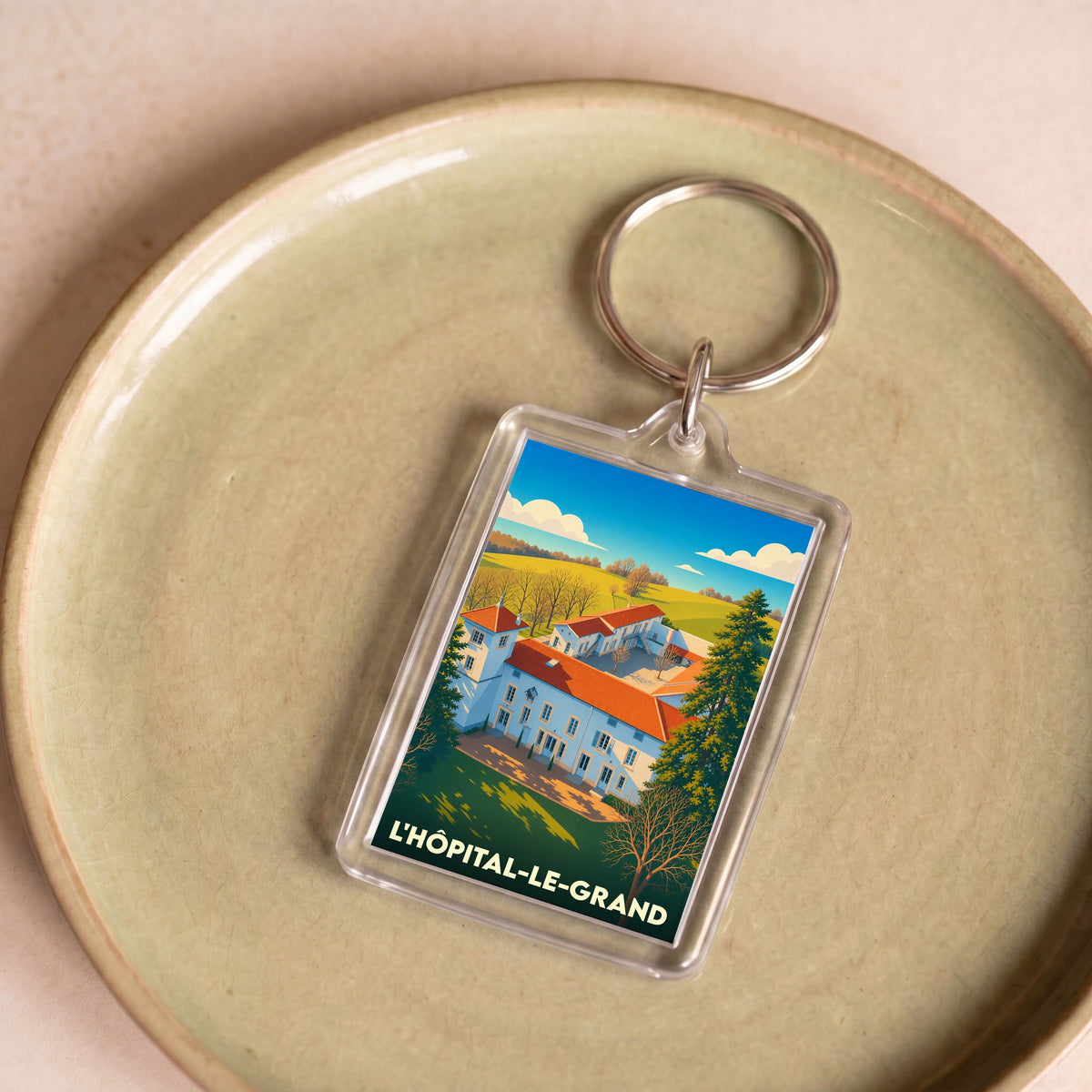 Porte-clés souvenir de la ville de L'Hôpital-le-Grand avec une illustration stylisée.