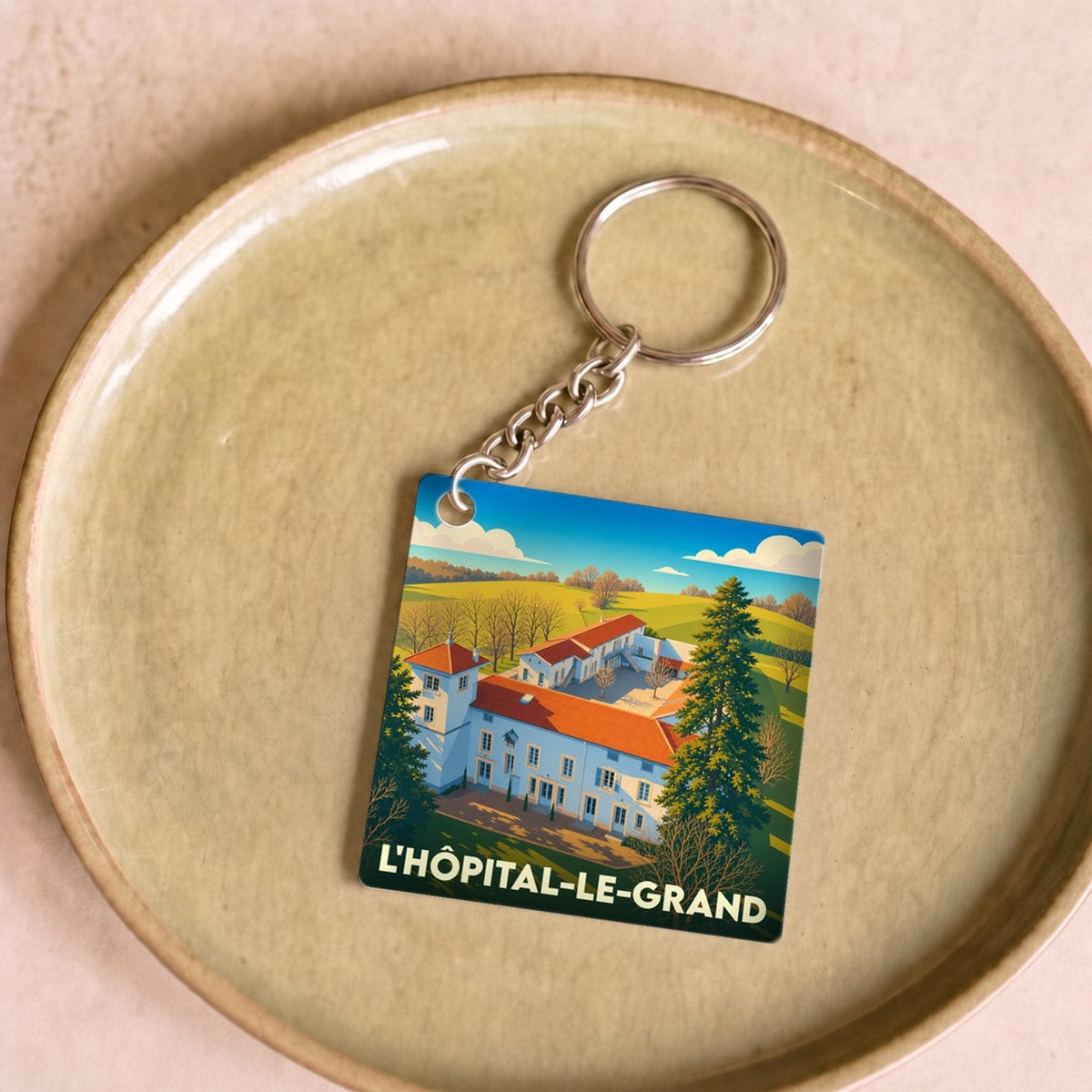 Porte-clés souvenir de la ville de L'Hôpital-le-Grand avec une illustration stylisée.