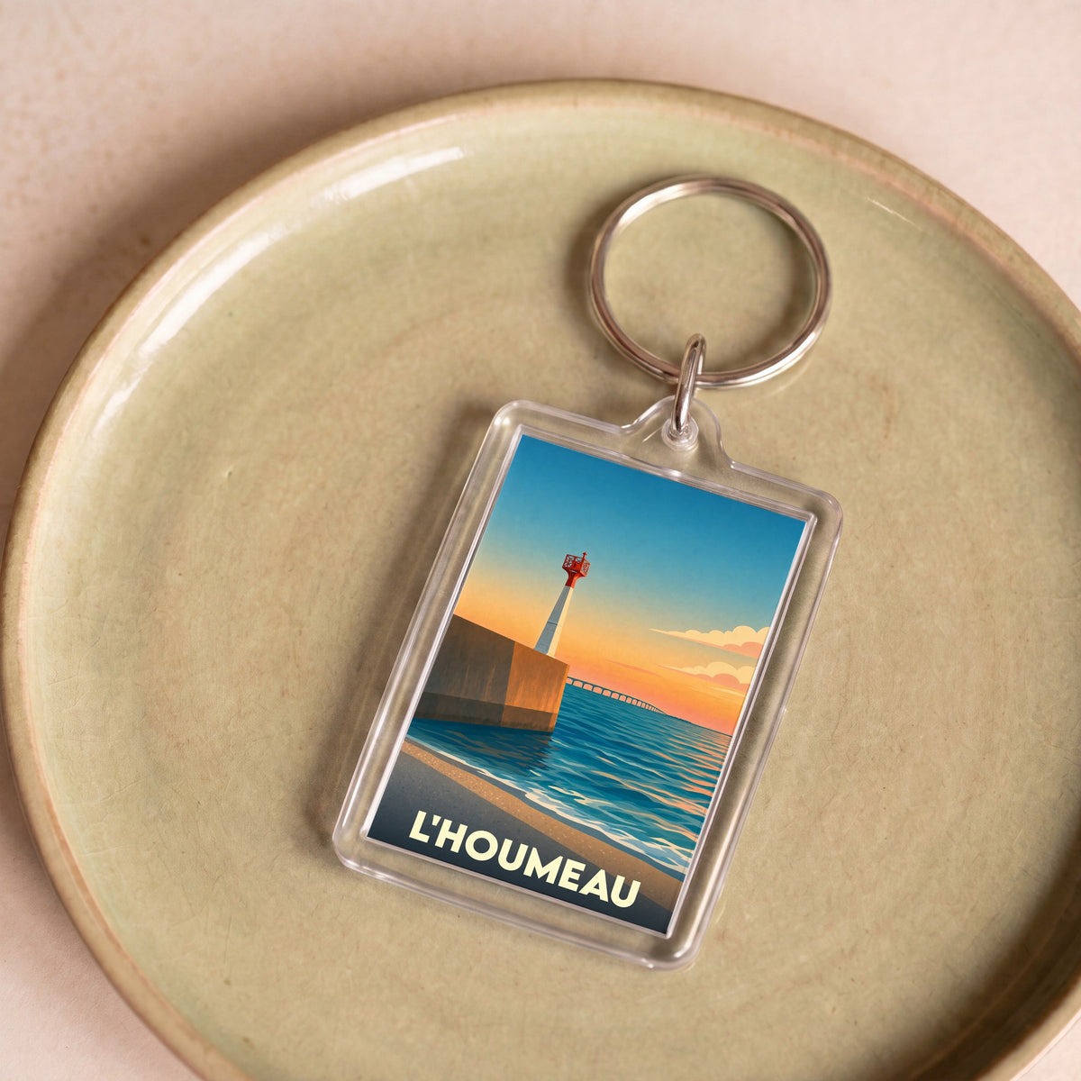 Porte-clés souvenir de la ville de L'Houmeau avec une illustration stylisée de son littoral au coucher du soleil.