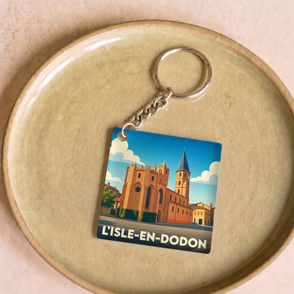 Porte-clés souvenir de la ville de L'Isle-en-Dodon avec une illustration stylisée.
