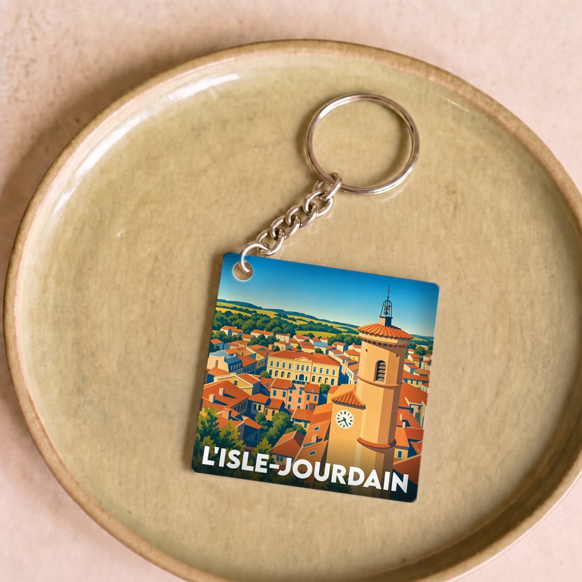 Porte-clés souvenir de la ville de L'Isle-Jourdain avec une illustration stylisée.
