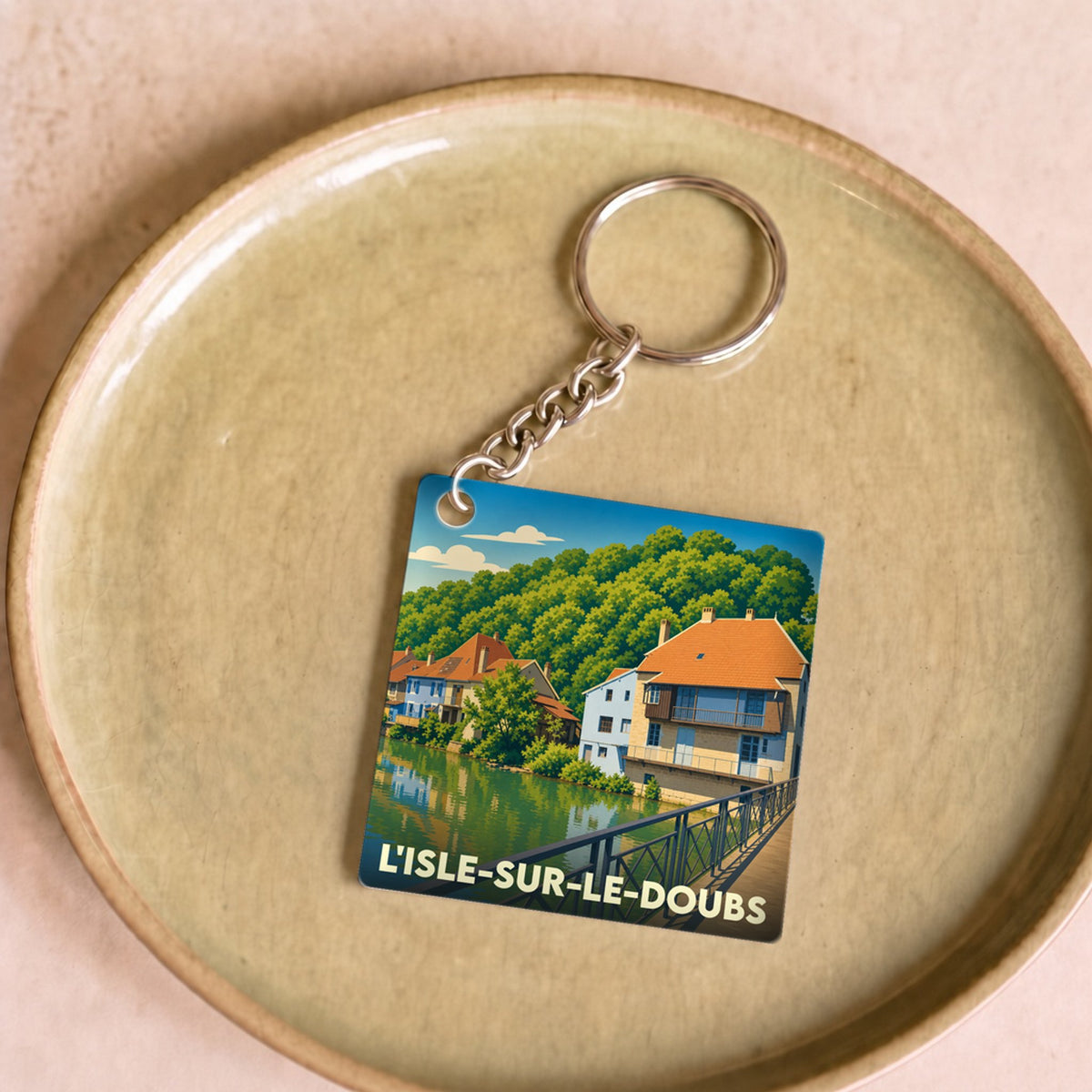 Porte-clés souvenir de la ville de L'Isle-sur-le-Doubs avec une illustration stylisée.