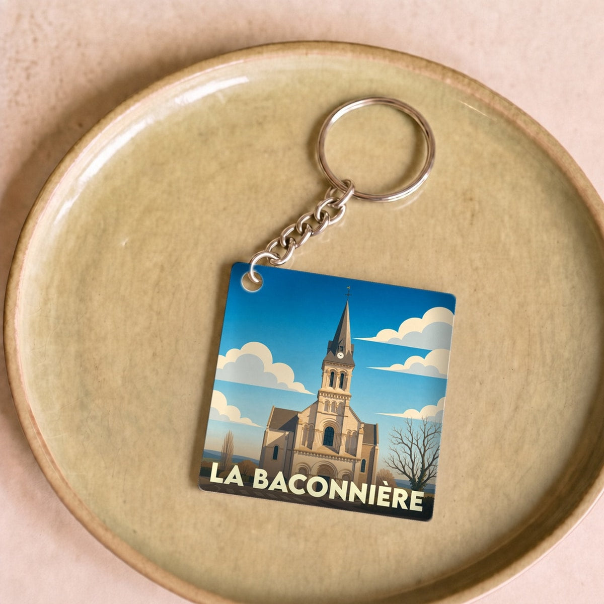 Porte-clés souvenir de la ville de La Baconnière avec une illustration stylisée de son église.