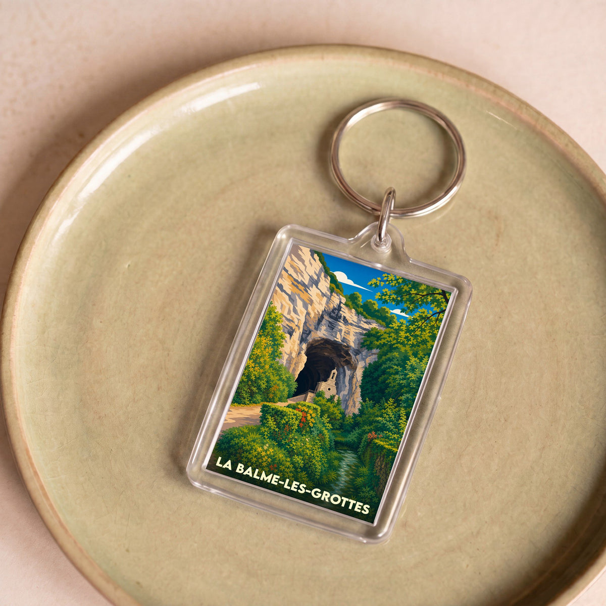 Porte-clés souvenir de la ville de La Balme-les-Grottes avec une illustration stylisée.