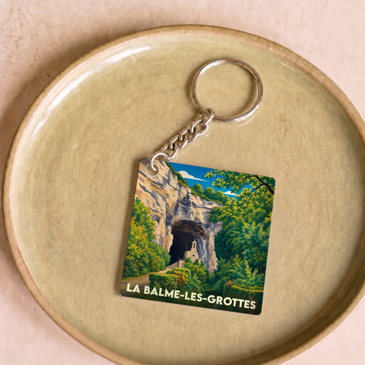 Porte-clés souvenir de la ville de La Balme-les-Grottes avec une illustration stylisée.
