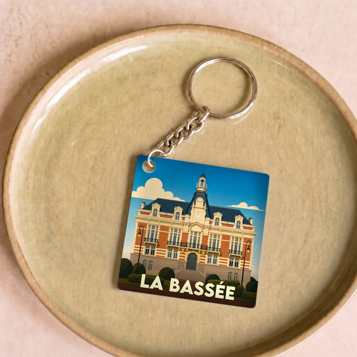 Porte-clés souvenir de la ville de La Bassée avec une illustration stylisée de son hôtel de ville.