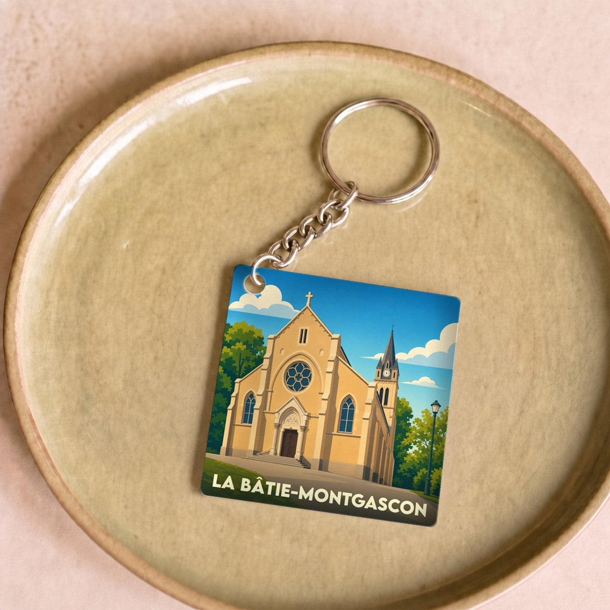 Porte-clés souvenir de la ville de La Bâtie-Montgascon avec une illustration stylisée de son église.