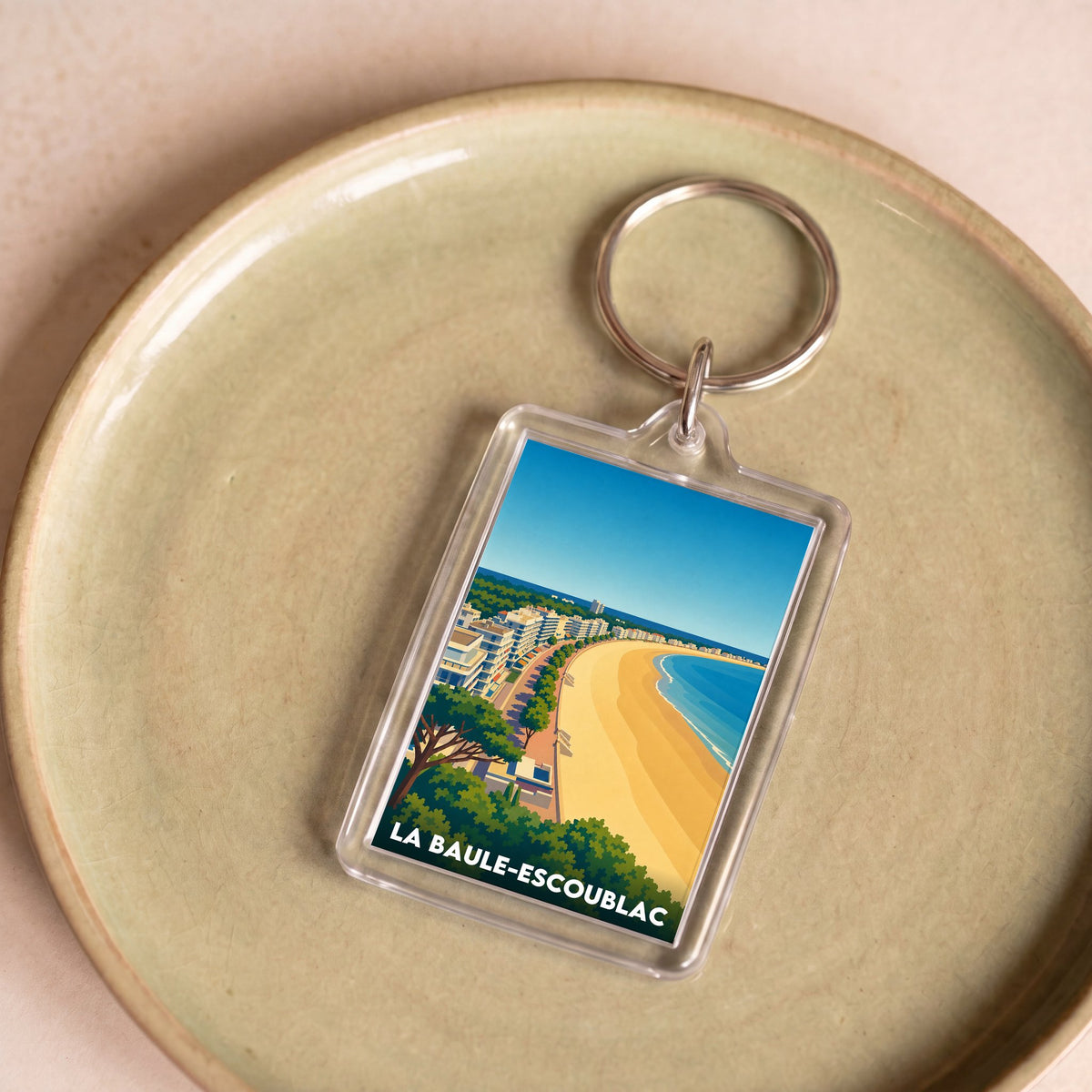 Porte-clés souvenir de la ville de La Baule-Escoublac avec une illustration stylisée.