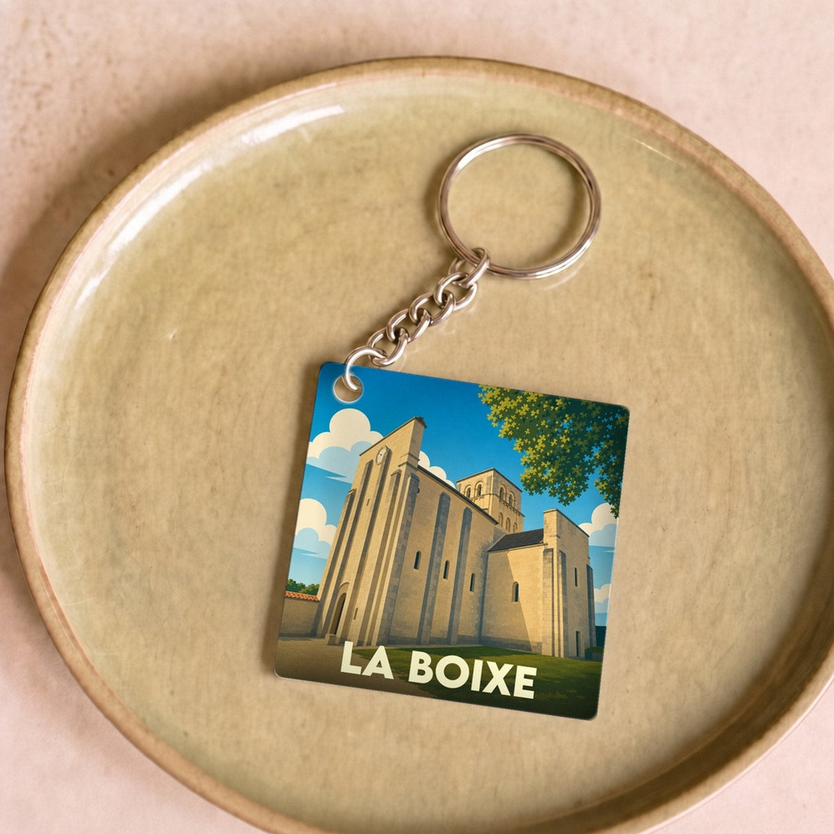 Porte-clés souvenir de la ville de La Boixe avec une illustration stylisée de son église.